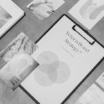 Black-and-white image of a brand strategy Venn diagram on a clipboard, surrounded by textures, color samples, and creative references.